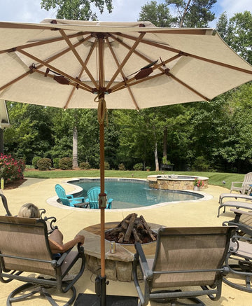 Alizé Antigua fan patio umbrella providing shade at residential backyard pool and fire pit