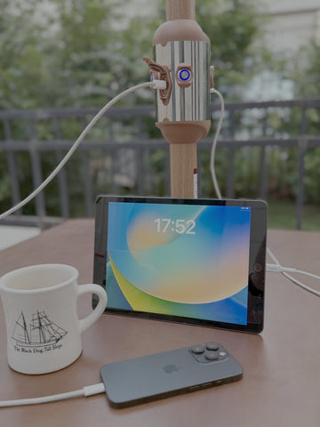Alizé patio umbrella built-in USB charging port powering a smartphone outdoors