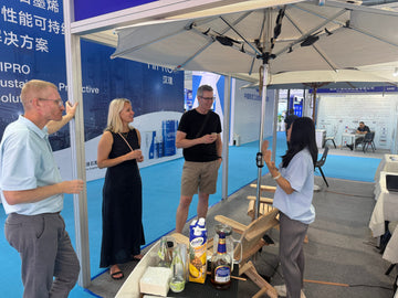 Visitors sharing Caribbean Painkillers under an Alizé fan umbrella at the Fuzhou International Boat Show in Mawei, with Pusser’s Rum, pineapple juice and wooden Adirondack chairs in the booth.