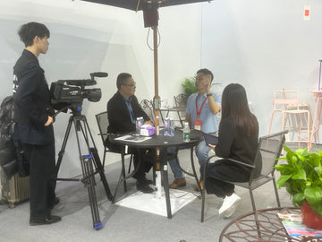 Alizé co-founder Tony Lee demonstrating the fan-integrated patio umbrella at CIFF Guangzhou