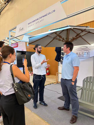Alizé Umbrella team demonstrating integrated fan patio umbrella system at international trade show with buyers and hospitality groups