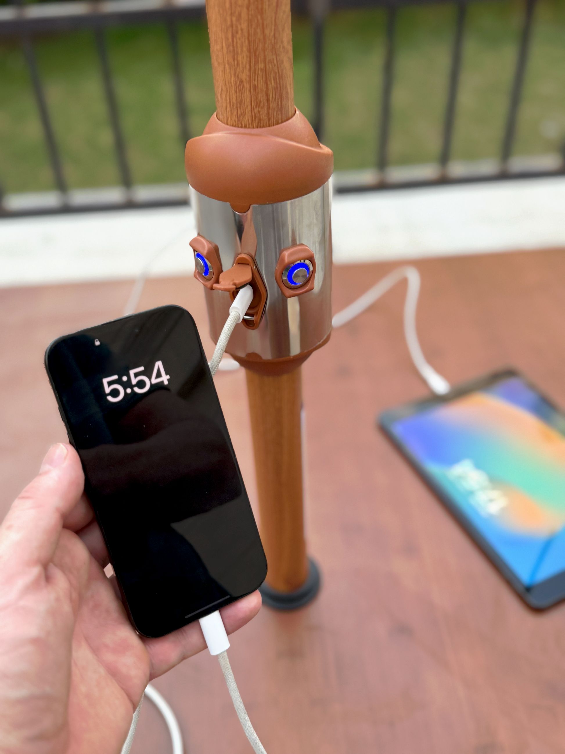 Phone charging via USB port on Alizé Antigua 10ft market umbrella wood grain pole outdoors on patio