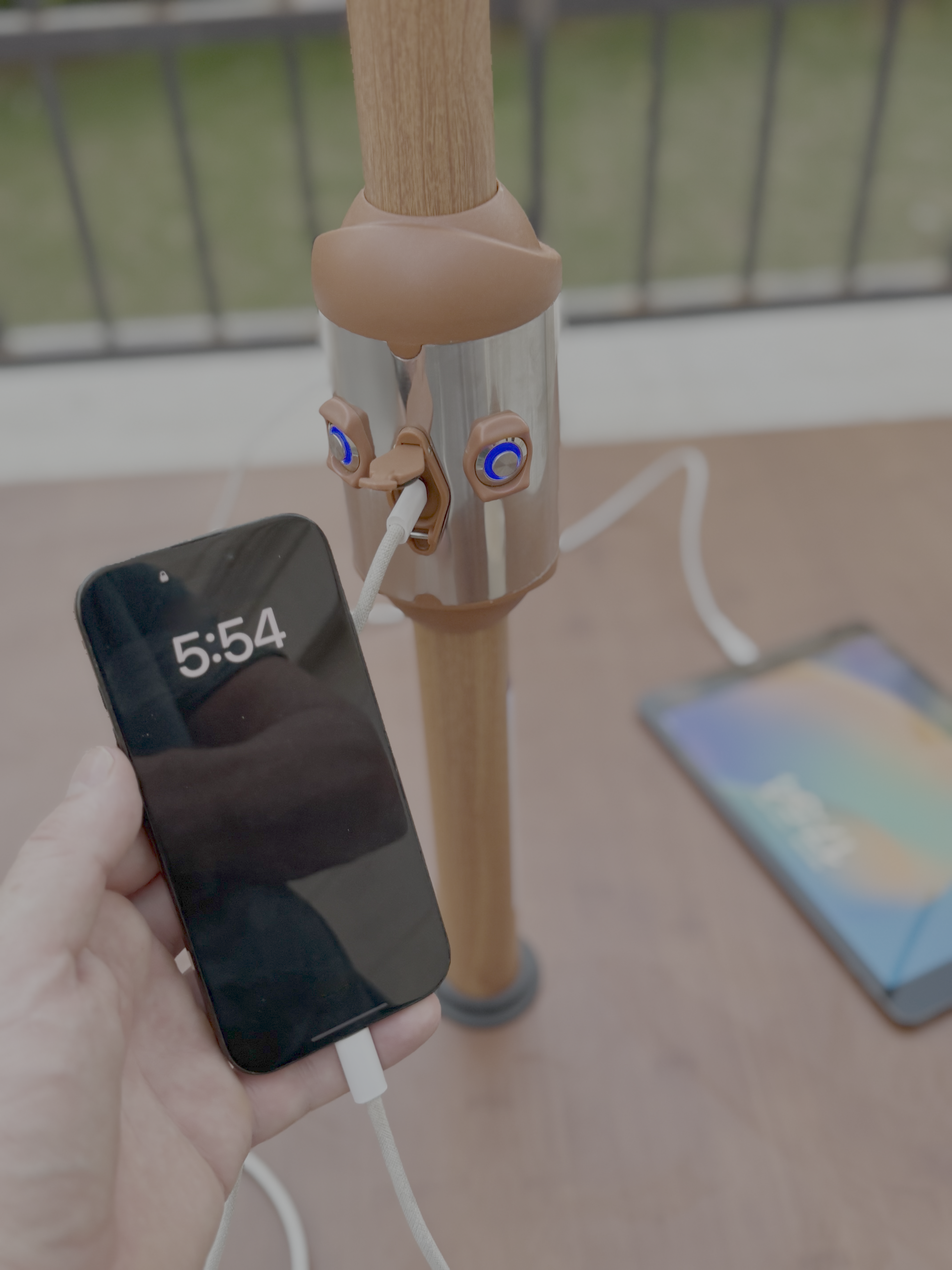 Phone charging via USB port on Alizé Antigua 10ft market umbrella wood grain pole outdoors on patio